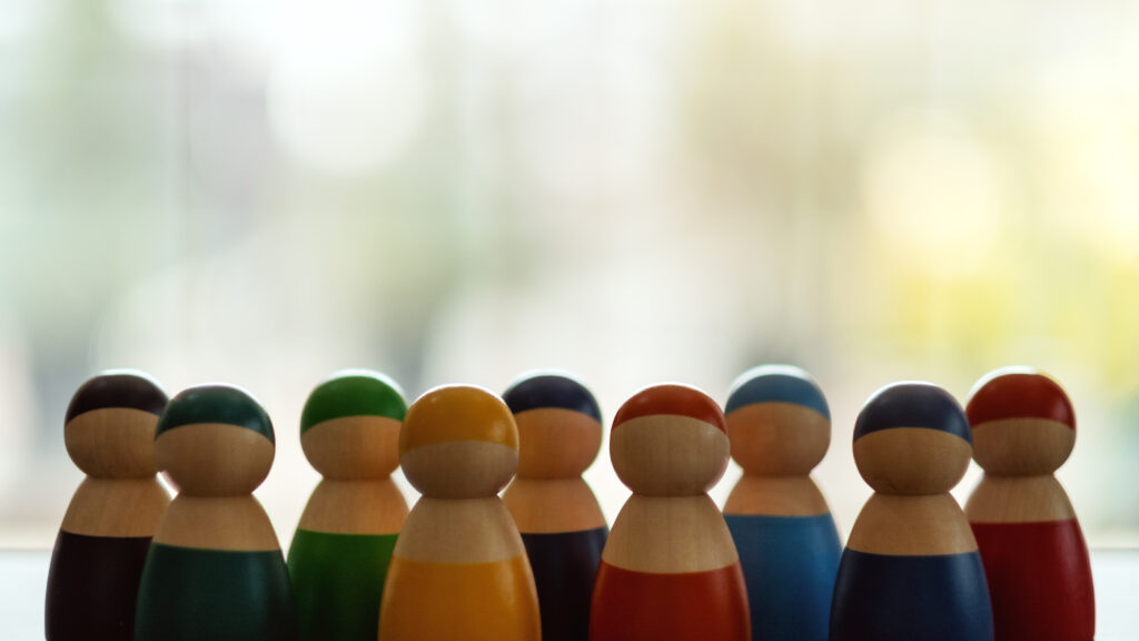 Group of wooden figurines in different colors standing in a row