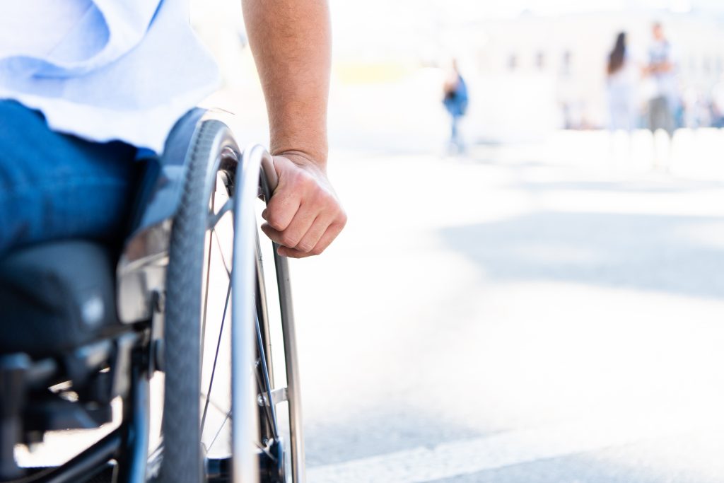 cropped image of disabled man using wheelchair on street