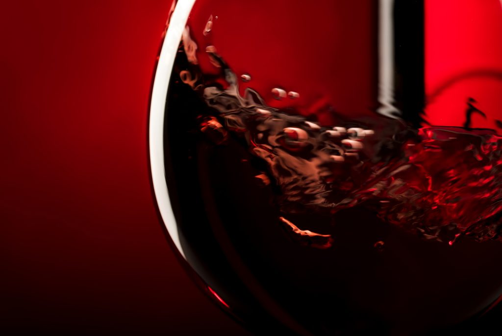 Red wine on red black background, abstract splashing. Macro shot