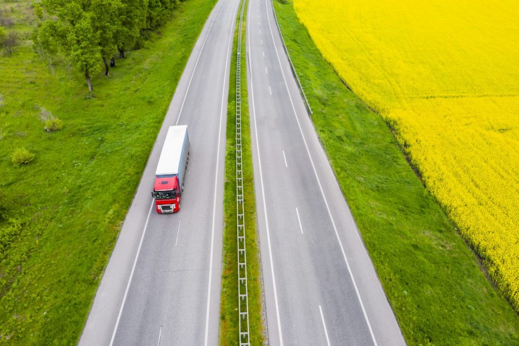 aerial-view-of-a-truck-on-the-highway-at-sunset-sh-AZTPPGP