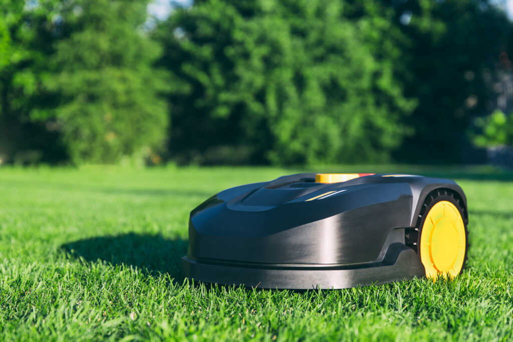 Robotic Lawn Mower cutting grass in the garden. Automatic robot