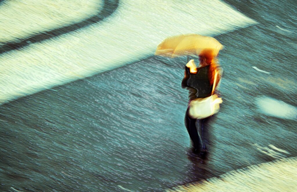 rainy-day-view-from-above-woman-walking-across-t-2022-11-14-05-11-36-utc